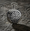 Silver pocket watch with Celtic knot design on a white background