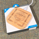 Clan Crest Bamboo Wireless Phone Charger on a desk, showcasing its elegant design and unique engraved clan crest.
