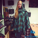The Laird Hooded Scarf Cape showcasing a vibrant tartan pattern, perfect for adding style and warmth on chilly days.